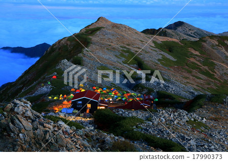 A snowy mountain hut near the evening mountains 17990373