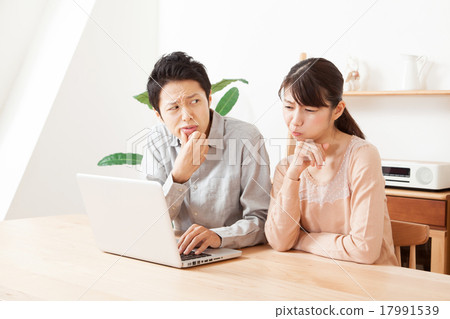 男性和女性夫婦通過看個人計算機的屏幕困擾 17991539