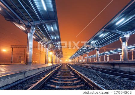 Railway station at night. Train platform in fog 17994802