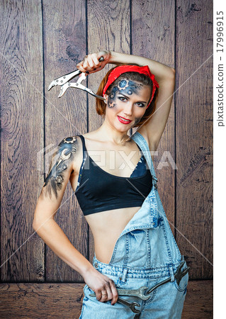Girl mechanic with face art posing with instrument Girl mechanic with face art posing with instrument 17996915