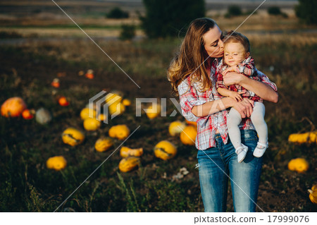 mother and daughter on a field with pumpkins 17999076