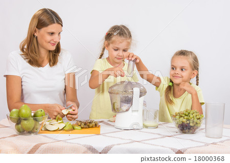 Children throw the fruit in a juicer in the care of mothers 18000368