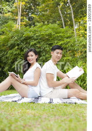 An Asian young couple dating in a park. An Asian young couple dating in a park. 18001689