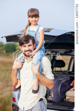 Cute male parent and child in meadow near car Cute male parent and child in meadow near car 18007782