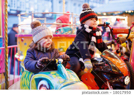 Little boy and girl on a carousel at Christmas market Little boy and girl on a carousel at Christmas market 18017950