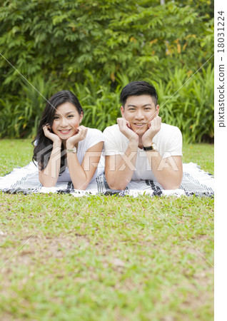 A young Asian couple enjoying a day in a park. 18031224
