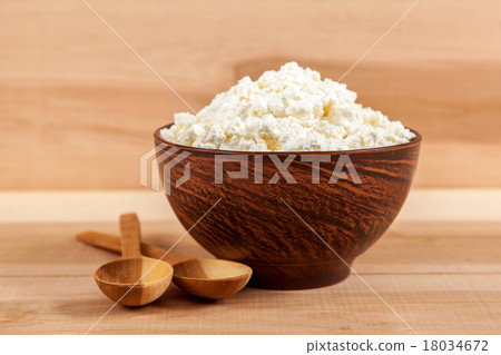 Fresh cottage cheese in a bowl with spoon. Fresh cottage cheese in a bowl with spoon. 18034672