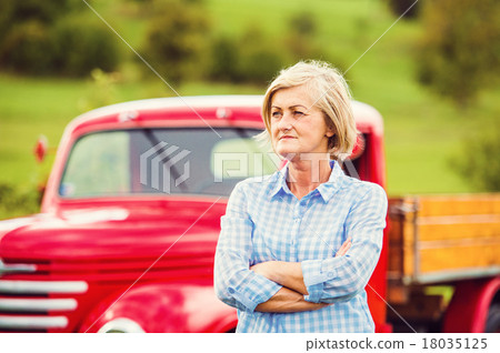 Senior woman with red car Senior woman with red car 18035125