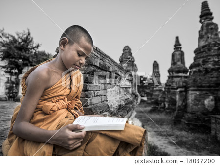 Novice monk reading outdoors 18037200