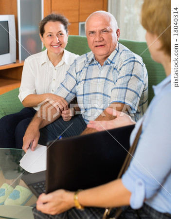 Senior couple with social worker at home Senior couple with social worker at home 18040314