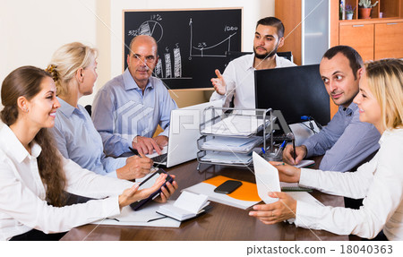 colleagues discussing price development at office colleagues discussing price development at office 18040363