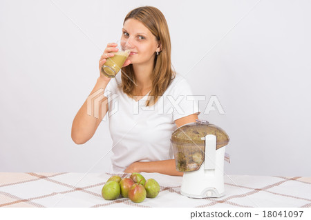 Girl freshly cooked pear juice and drink it 18041097