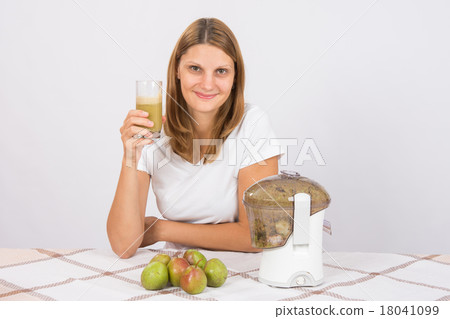 The girl is holding a glass of pear juice 18041099