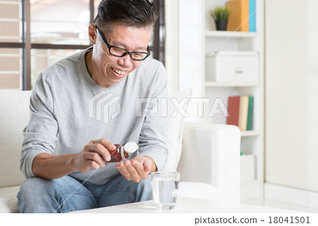 Asian man eating supplement 18041501