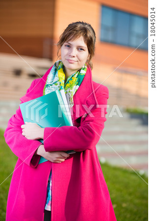 Portrait of young alluring woman holding education Portrait of young alluring woman holding education 18045014