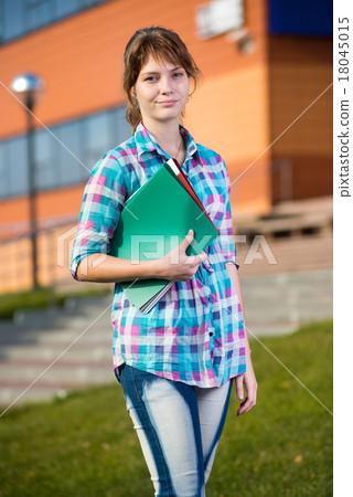 Portrait of young alluring woman holding education 18045015