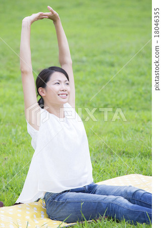 A woman taking a deep breath in the meadow 18046355