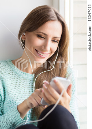 Young smiling woman having fun with listening to music Young smiling woman having fun with listening to music 18047013