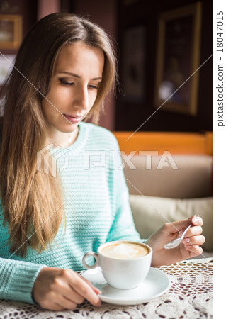 Young beautiful lady having coffee break in the cafe. Young beautiful lady having coffee break in the cafe. 18047015