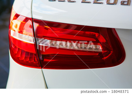 Back view and red headlight of white automobile 18048371