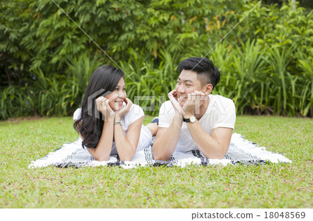 A young Asian couple looking at each other. 18048569