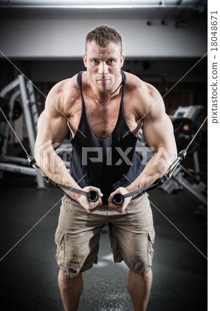 Stock Photo: Bodybuilder doing butterfly on cable pull