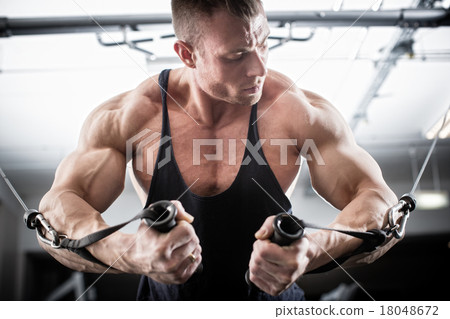 Stock Photo: Bodybuilder doing butterfly on cable pull