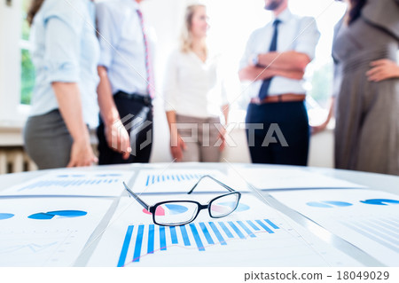 Business people in office with financial data 18049029