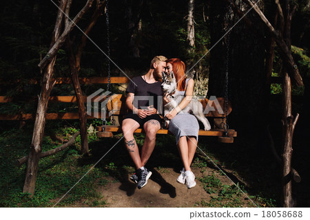 beautiful couple together with dog on a swing beautiful couple together with dog on a swing 18058688