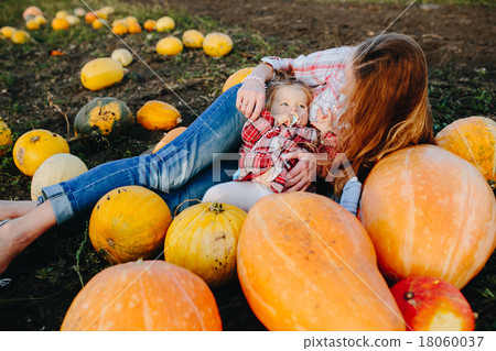 mother and daughter lie between pumpkins 18060037