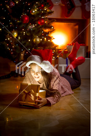 girl lying on floor and looking inside of gift box girl lying on floor and looking inside of gift box 18063417