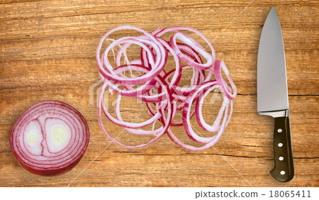 knife on cutting board and sliced red onion 18065411