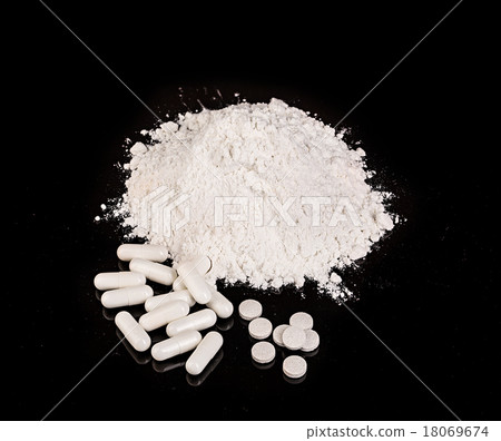 drug powder tablets and capsules close-up on black 18069674