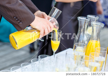 Hand of a man pouring orange juice on a wedding 18072728