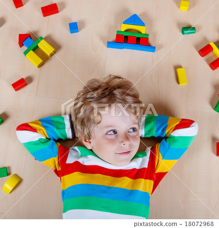 Little blond child playing with colorful wooden blocks indoor Little blond child playing with colorful wooden blocks indoor 18072968