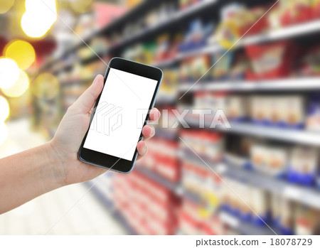 hand holding a modern smartphone in supermarket 18078729