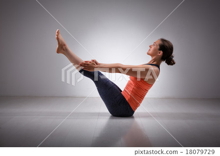 Woman practices yoga asana Paripurna navasana Woman practices yoga asana Paripurna navasana 18079729