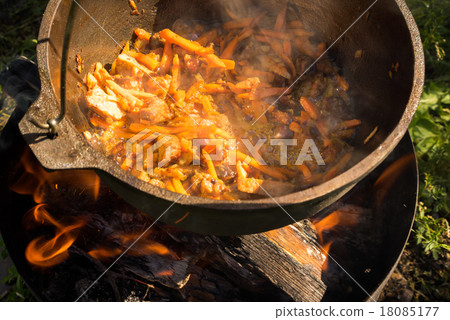 cooking meat, onion and carrot in a metal pan 18085177