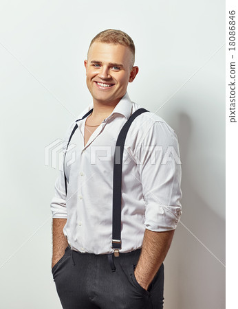 Portrait of smiling young man in white shirt and suspenders 18086846