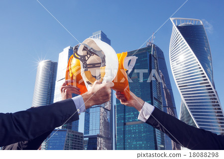 Business people clinking helmets Business people clinking helmets 18088298