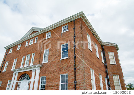 Red brick building with a white frame lattice window 18090098