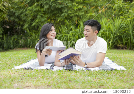 A young couple exchanging reading materials. A young couple exchanging reading materials. 18090253