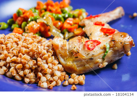 Oven baked rabbit legs with green peas and carrot 18104134