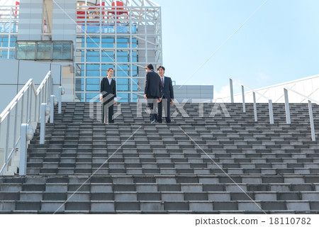 A businessman and a business woman coming and going through the stairs A businessman and a business woman coming and going through the stairs 18110782