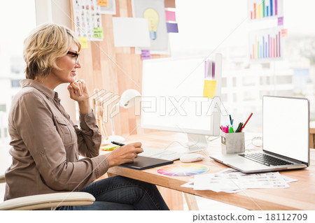 Casual designer working at her desk Casual designer working at her desk 18112709