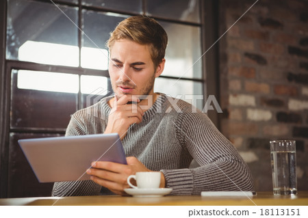 Handsome man focusing on tablet computer Handsome man focusing on tablet computer 18113151