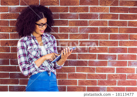Attractive hipster leaning on wall and using tablet Attractive hipster leaning on wall and using tablet 18113477
