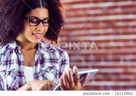 Attractive hipster smiling and using tablet 18113662