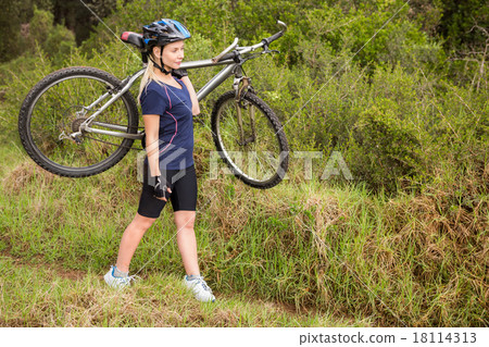 Athletic blonde carrying her mountain bike 18114313