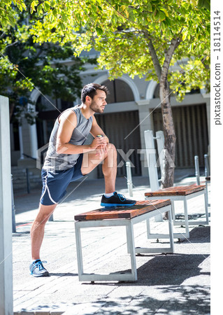 Handsome athlete doing leg stretching on a bench 18114514